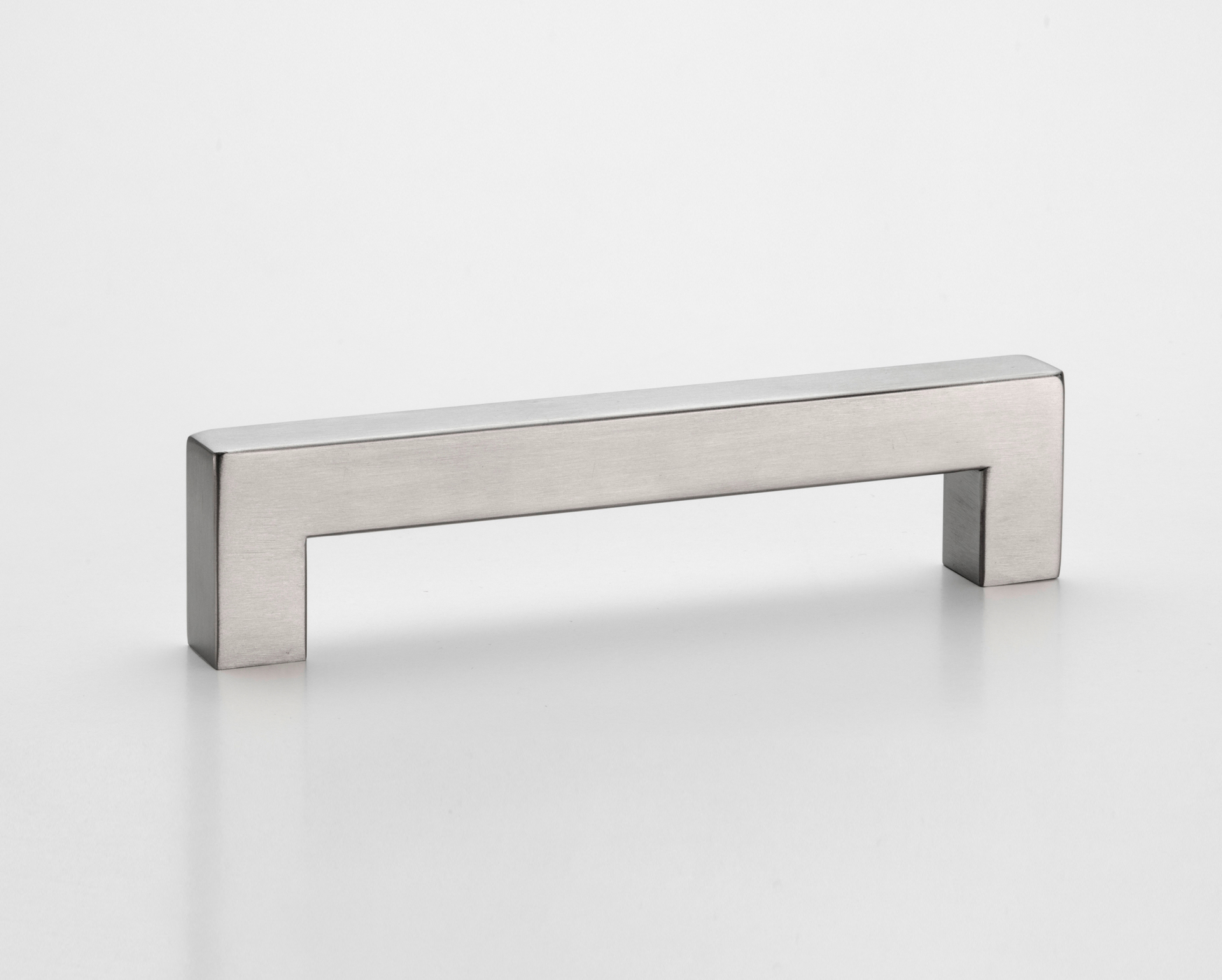 Eurolaton | Auf einem schlichten weißen Hintergrund ist ein rechteckiger, silberfarbener Möbelgriff aus Edelstahl im modernen, minimalistischen Design abgebildet.